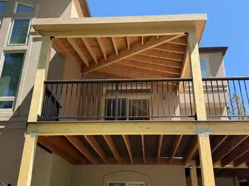 Covered deck framing with exposed rafters and timber posts