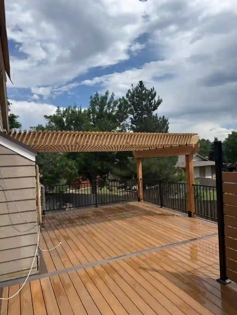 Wide view of a completed deck and timber pergola under a cloudy sky
